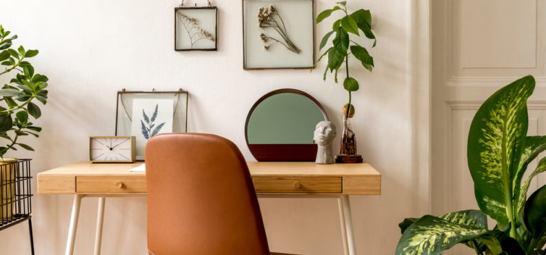 Home office with beautifully placed greenery. Perfect background for work Zoom calls. Find out what other living room decor styles are in!