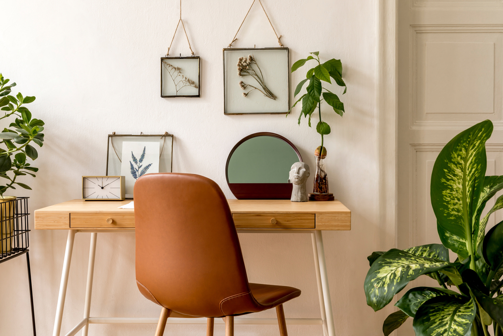 Home office with beautifully placed greenery. Perfect background for work Zoom calls. Find out what other living room decor styles are in!