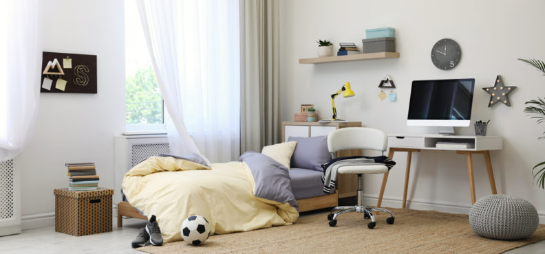 Stylish teenager's room interior with comfortable bed and workplace