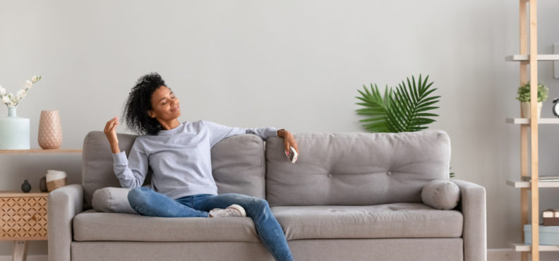 Relaxed,Woman,Sitting,On,Comfortable,Couch,In,Living