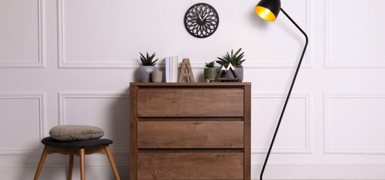 dresser, with, accessories, on, top, and, lamp, and, chair, on, either, side