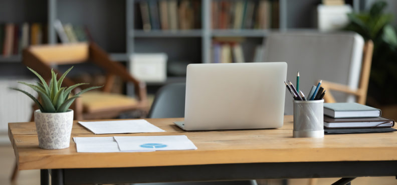 wooden, desk, with, laptop, lamp, papers, and, plant